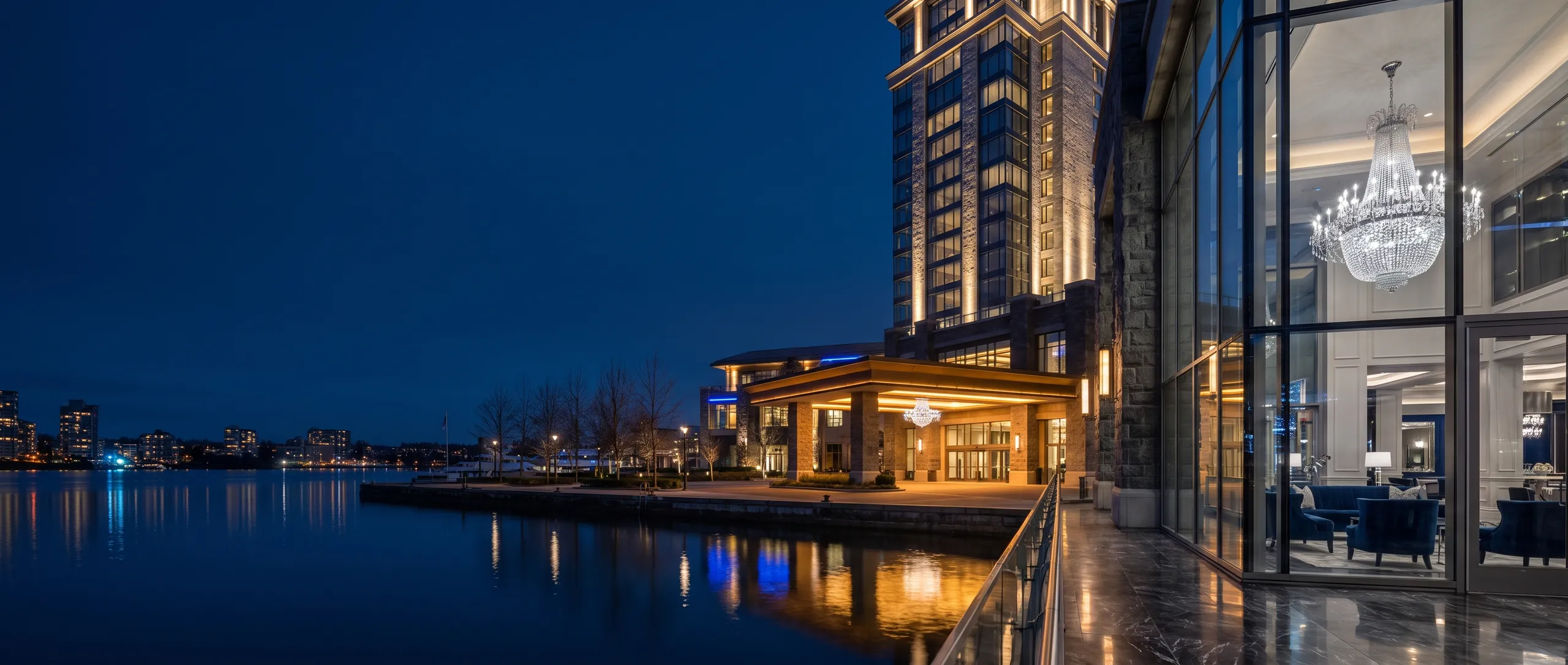 The Lucky Harbourcrest tower and porte-cochère at blue hour, seen across the harbour
